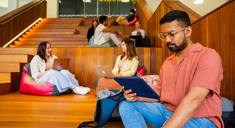 Students looking at tablets, laptops, and having discussions